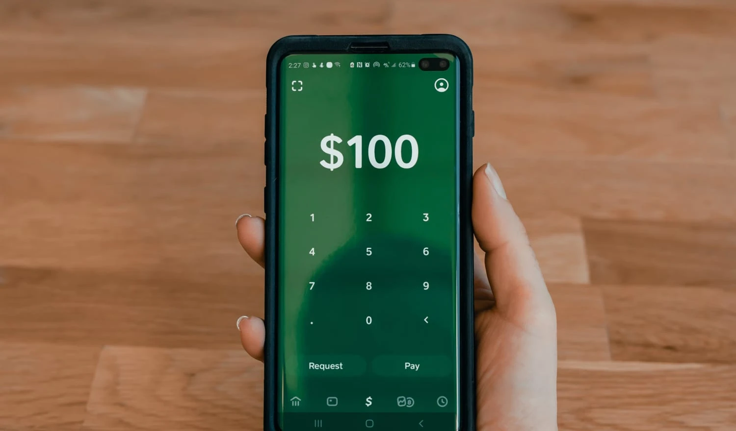 A woman holding a phone showing the Cash App