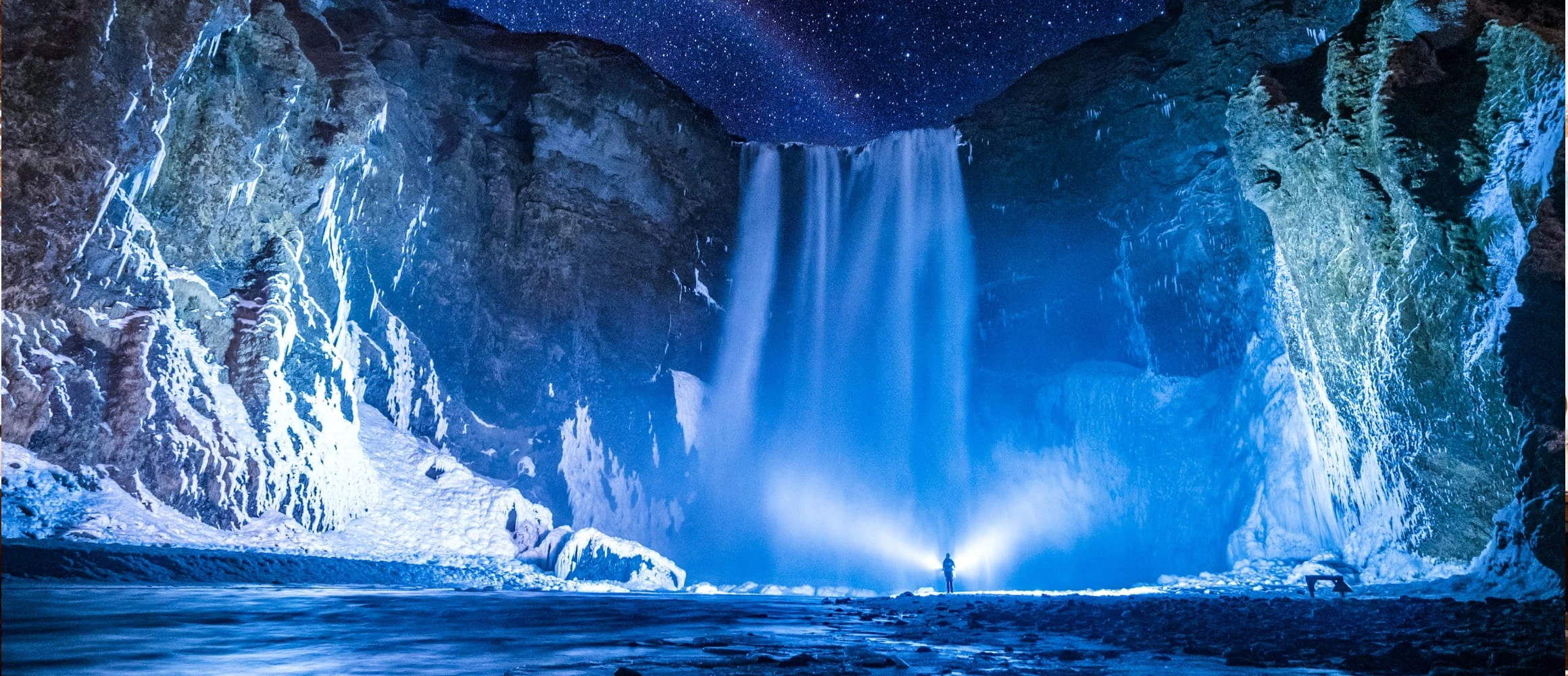 Person in front of waterfalls during night time