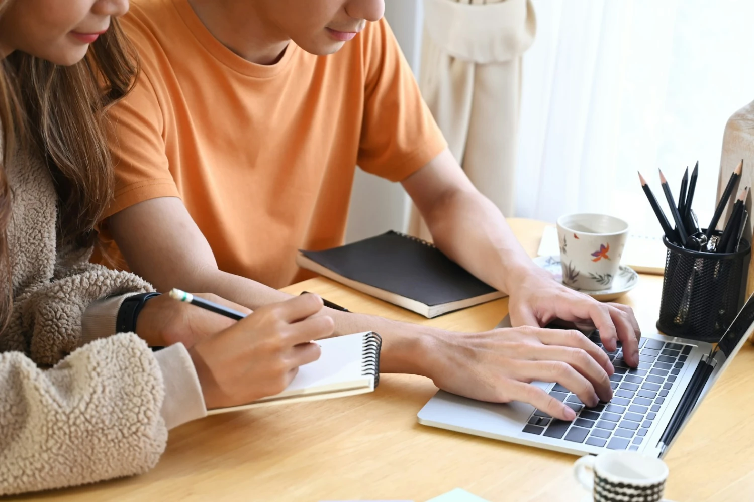 A couple using a computer to work on their wedding website