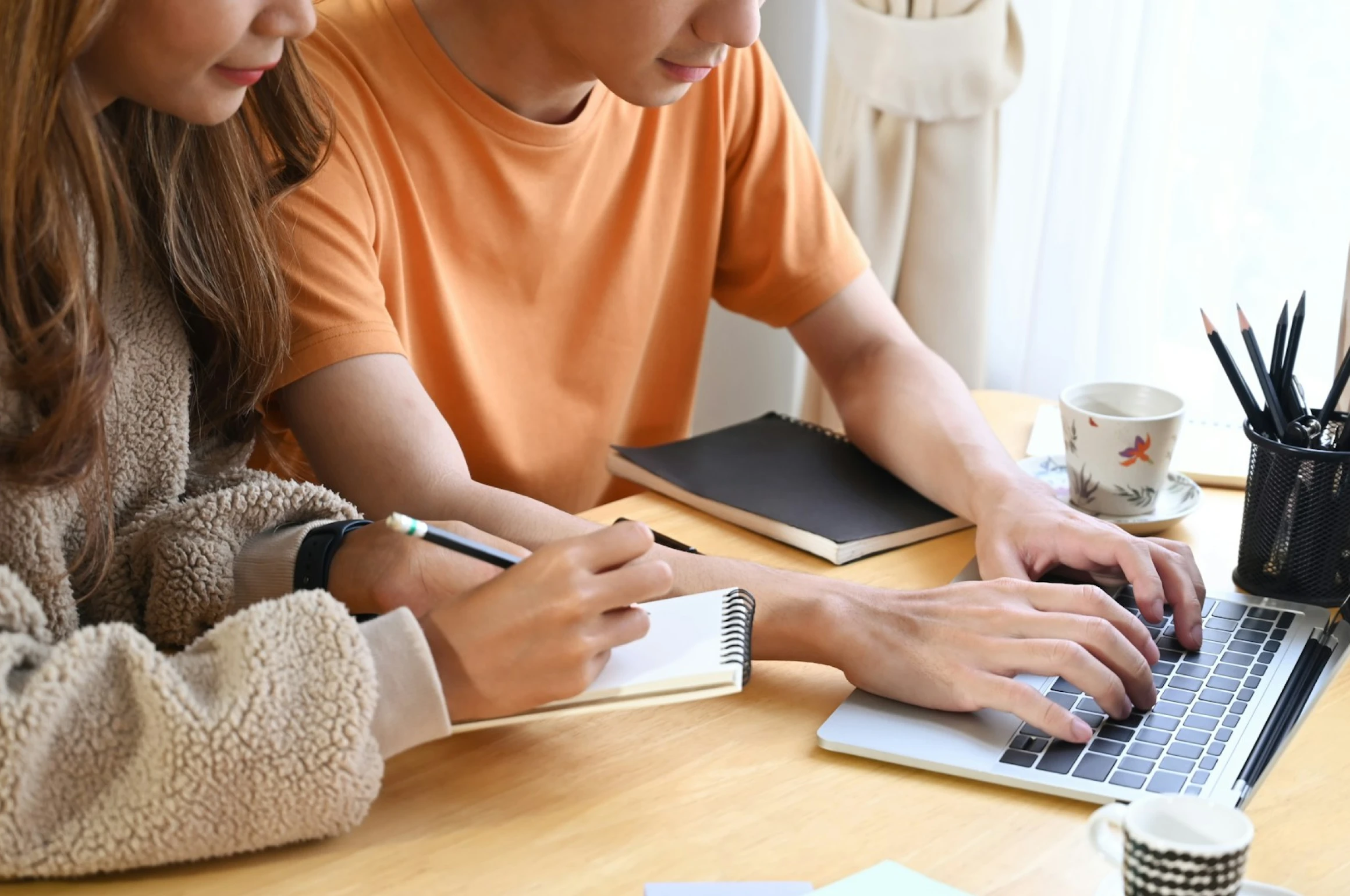 A couple using a computer to work on their wedding website