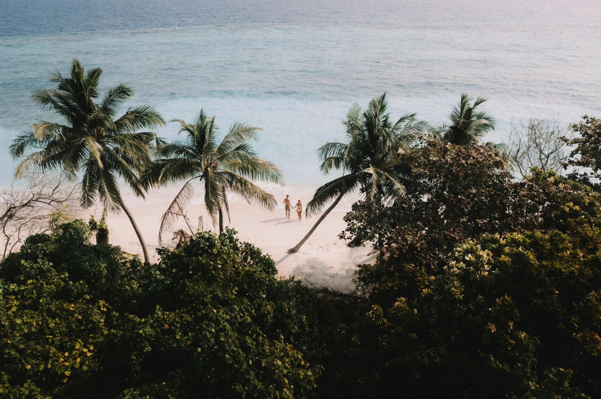 A pair of honeymooners on a secluded beach in paradise