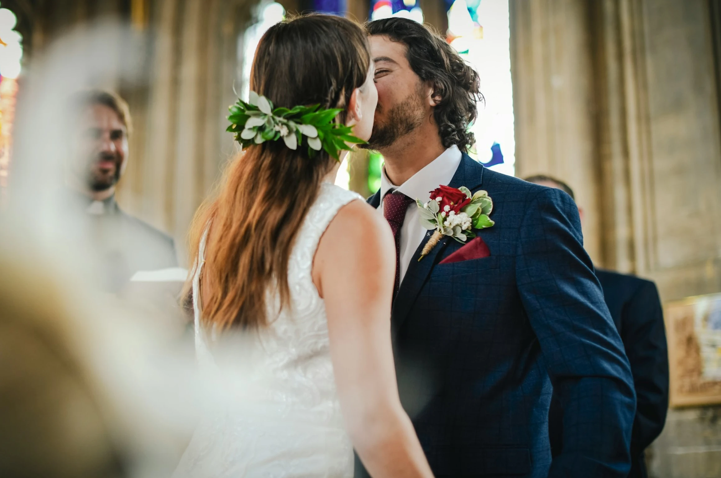 A newly married couple having their bridal kiss moment at the altar