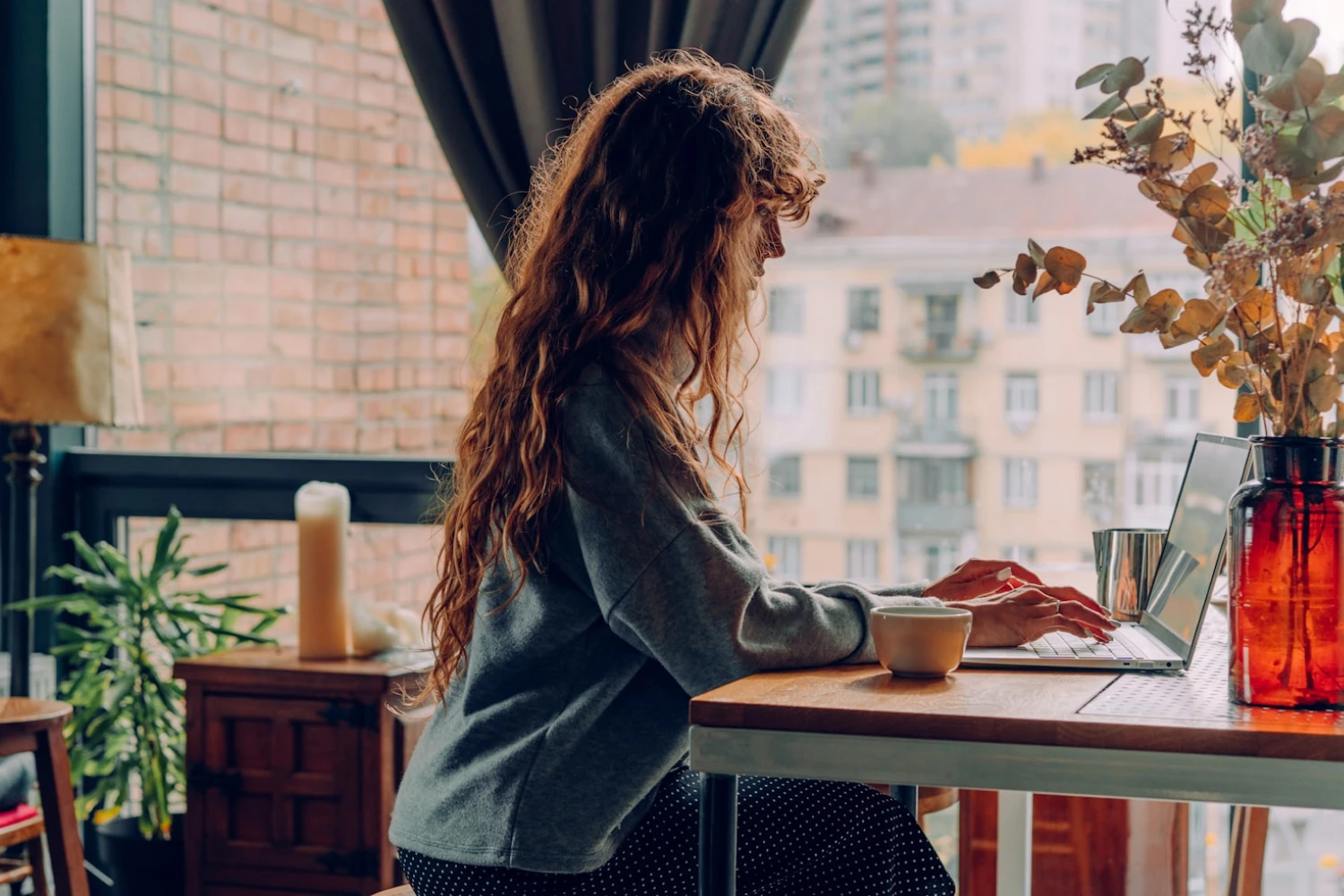 A woman writing text for her upcoming honeymoon fund on her laptop