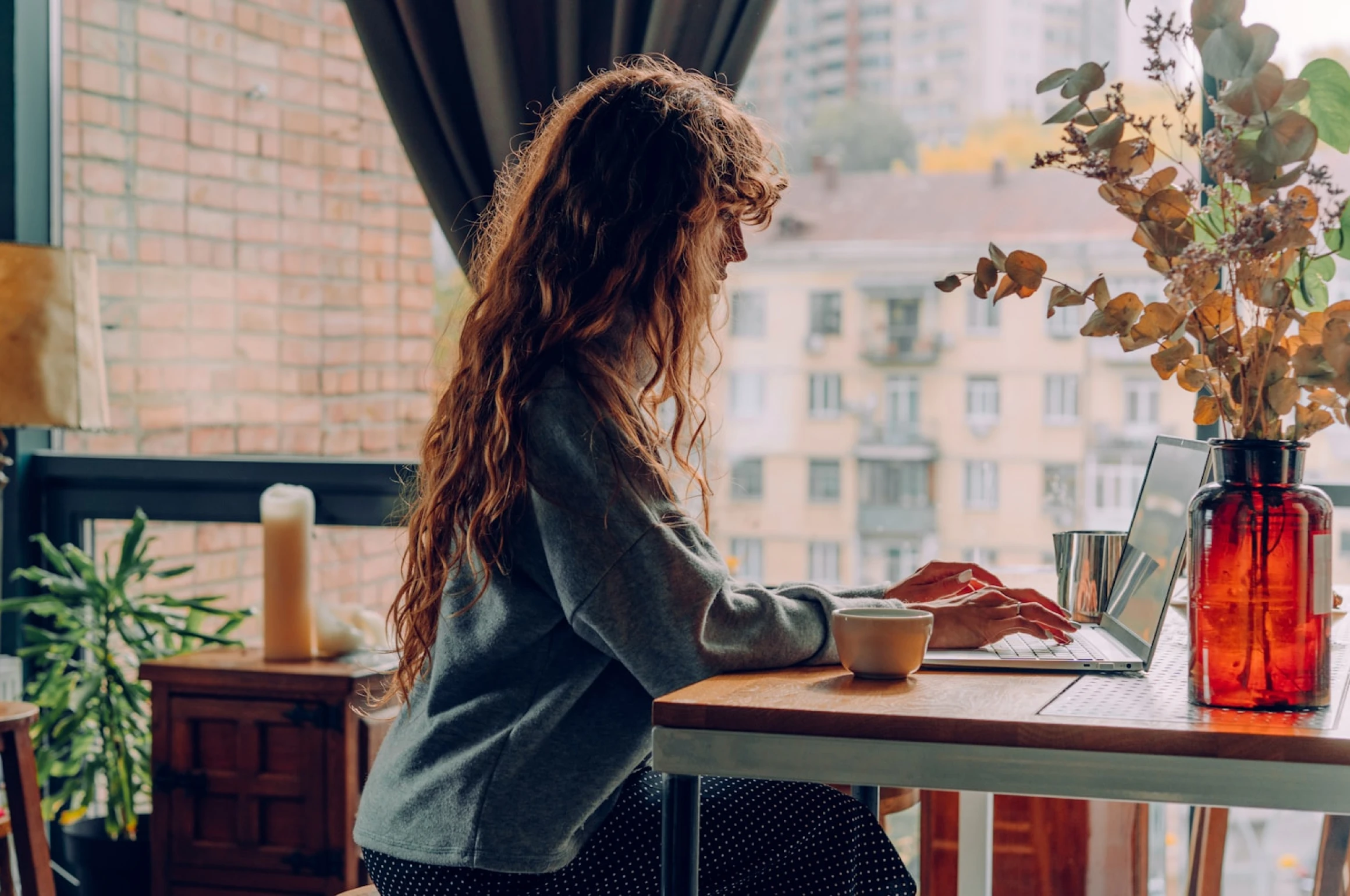 A woman writing text for her upcoming honeymoon fund on her laptop