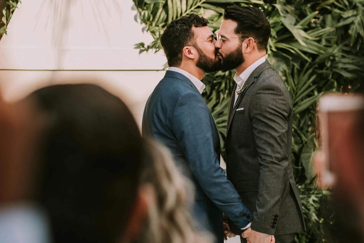 A couple kissing in front of a green landscape